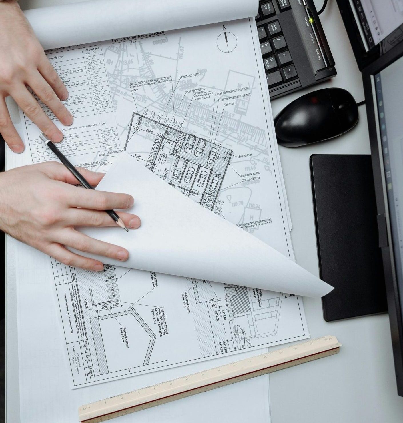 High-angle view of an architect reviewing construction drawings on a desk in an office.